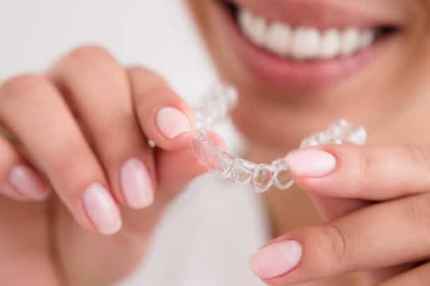 Teenager with braces smiling, showing why young individuals should avoid lazer whitening Reading